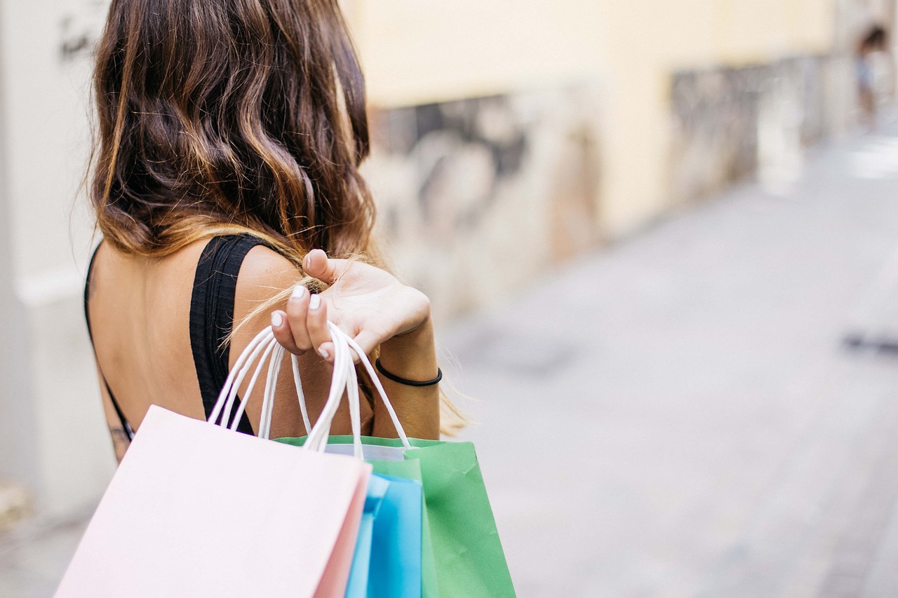 Woman carrying colorful shopping bags after a successful purchase, representing the importance of speed optimization for Shopify in delivering fast, smooth shopping experiences.