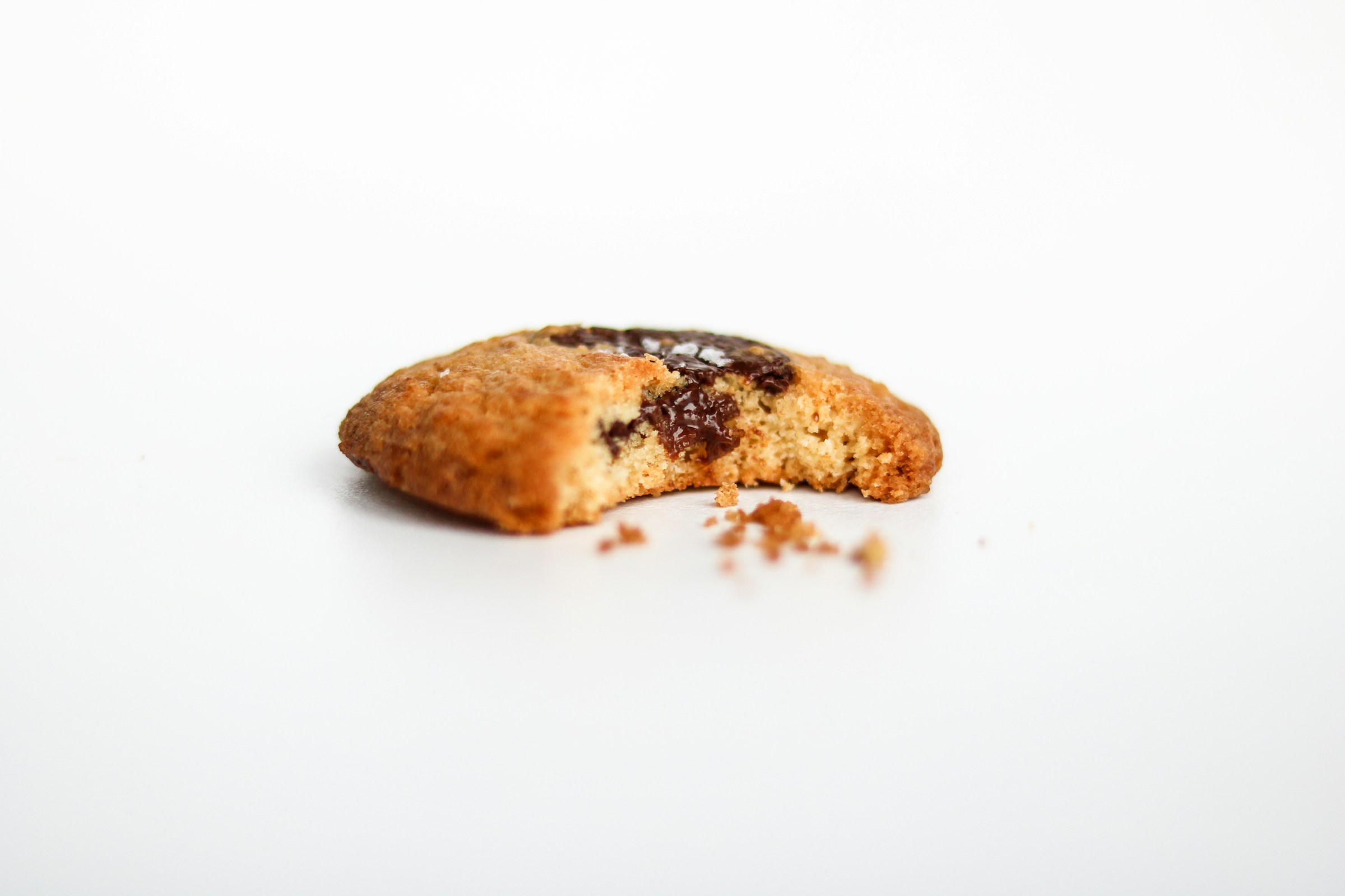 Tracking Pixels That Convert: How to Use Them Effectively 17 Half-eaten chocolate chip cookie with crumbs on a white background, symbolizing cookies and third-party tracking in online marketing.