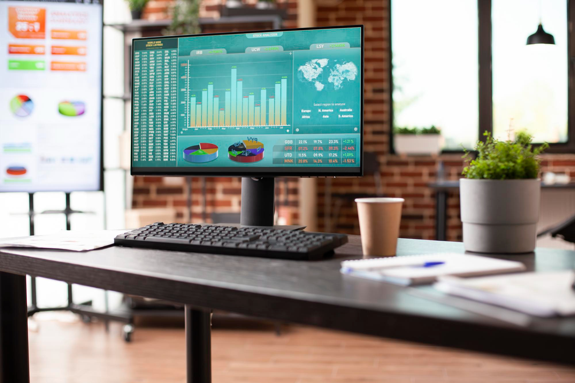 Computer monitor displaying charts, graphs, and analytics in a modern office, symbolizing Shopify apps for analytics and reporting, conversion rate optimization, and eCommerce performance tracking.