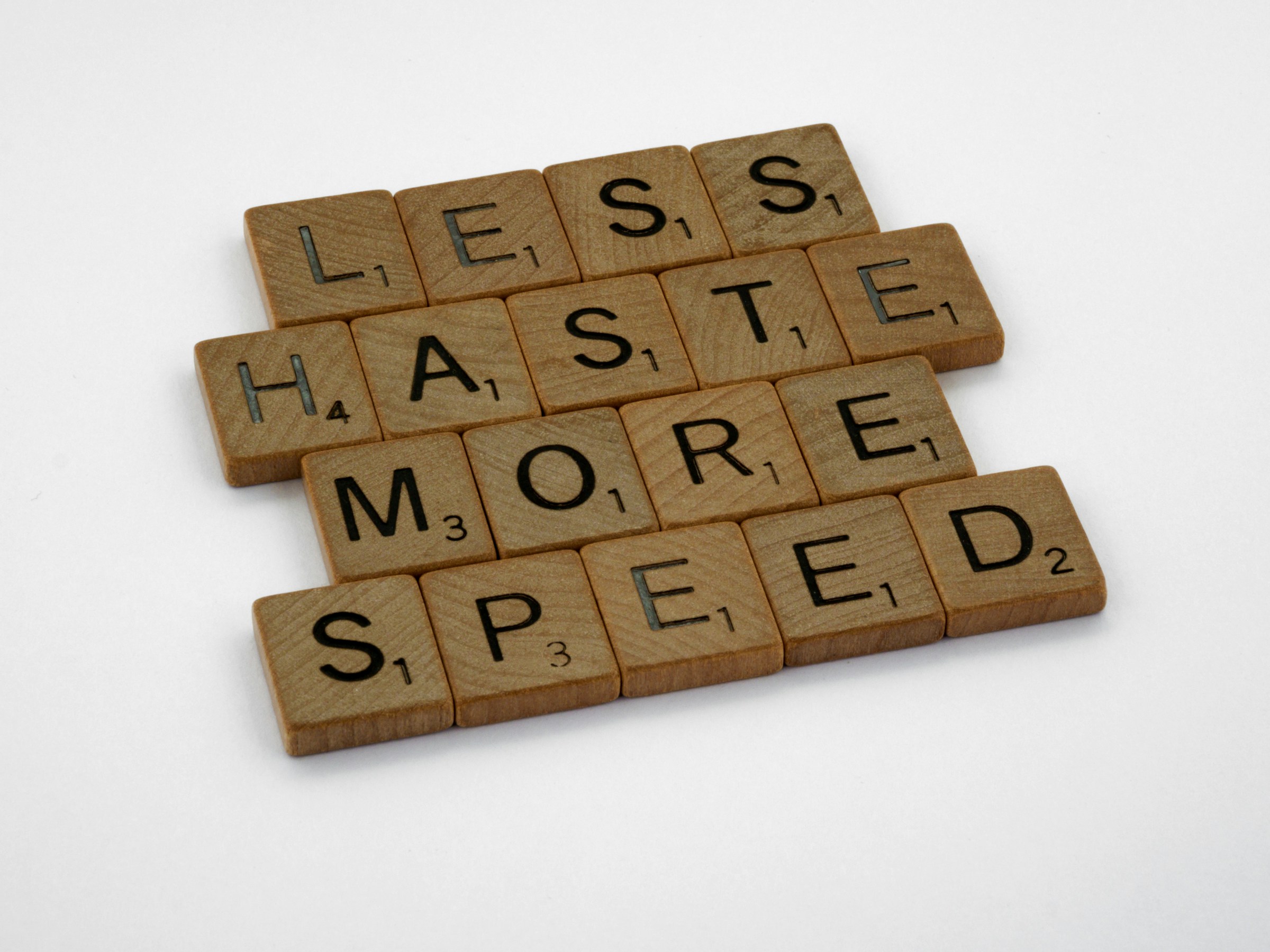 Tracking Pixels That Convert: How to Use Them Effectively 15 Scrabble tiles arranged to spell “Less haste more speed” on a white background, symbolizing smart optimization and efficient performance.
