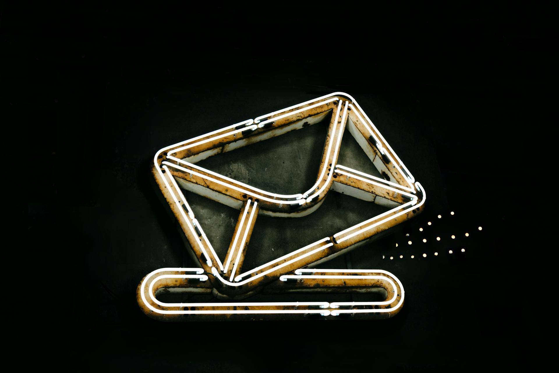 Rustic neon sign of an email envelope icon on a dark background, symbolizing email communication and ecommerce email marketing.