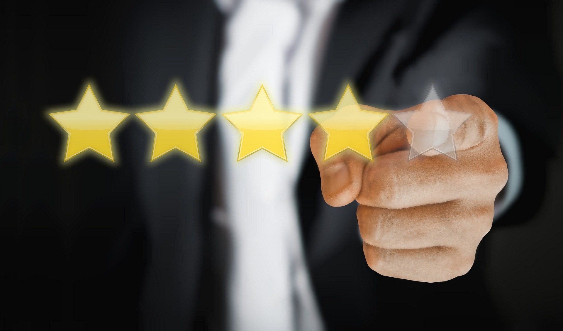 Businessman pointing at a four-star rating on a digital screen, representing customer reviews, star ratings, and service quality in ecommerce feedback systems.
