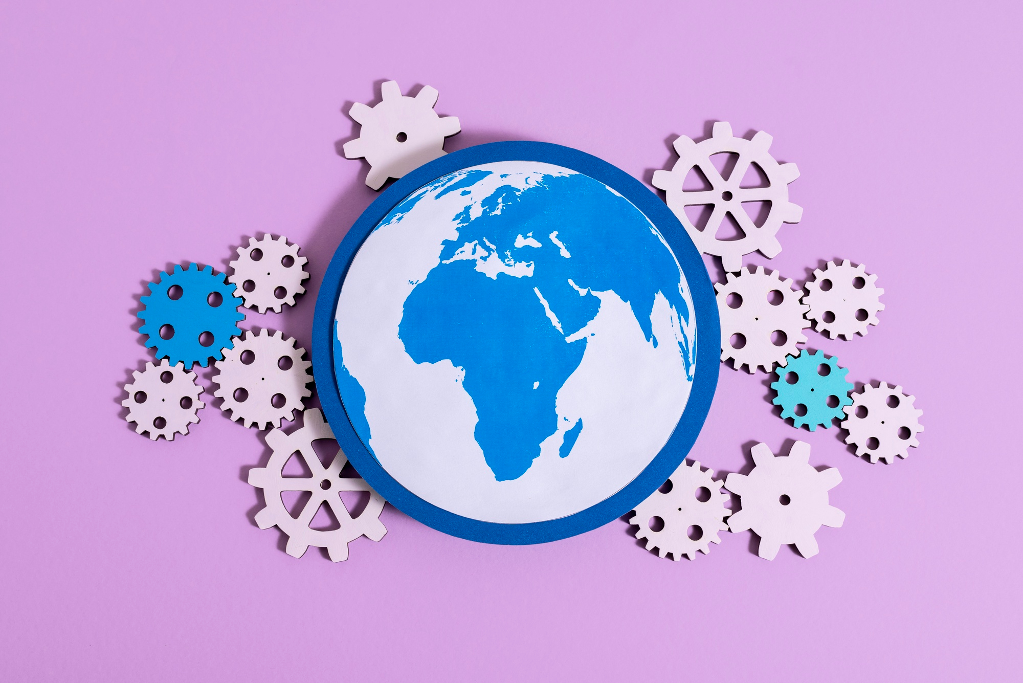 Understanding the Accessibility Act: A Shopify Merchant’s Guide to EAA 2025 15 Paper globe surrounded by gear icons on a pastel background, symbolizing how the EAA 2025 and global Accessibility Act regulations work together to drive inclusive ecommerce and digital accessibility worldwide.