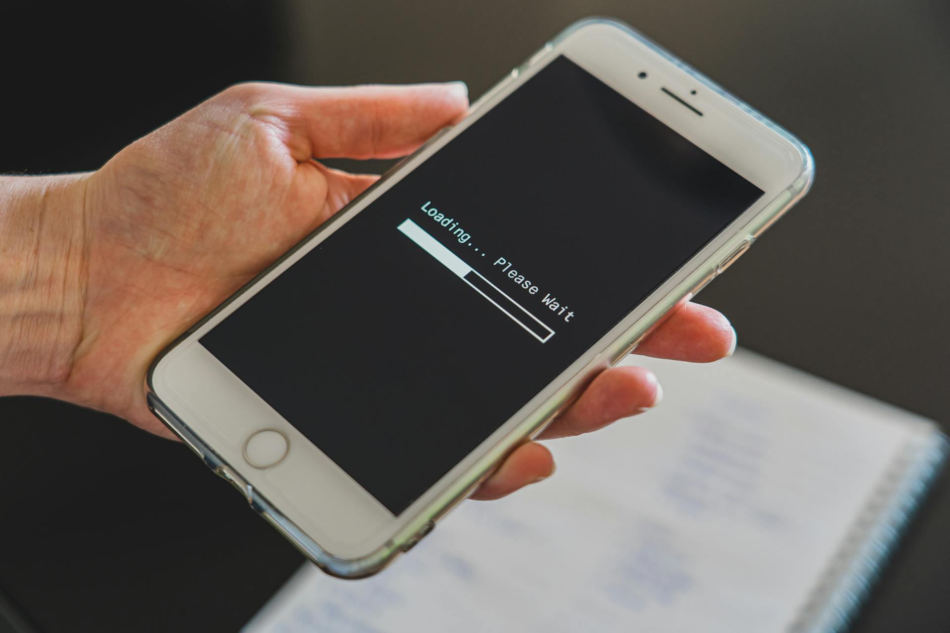 Smartphone screen showing loading bar with message please wait
