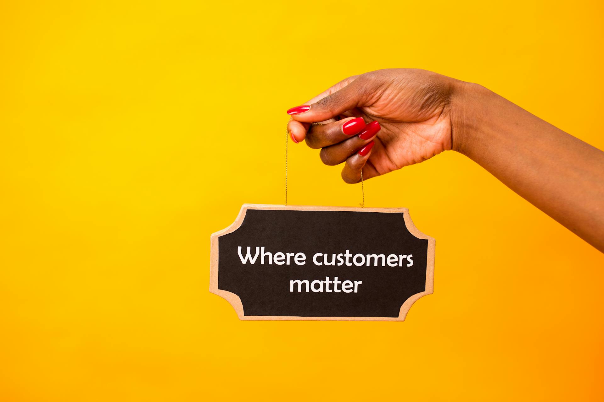 Hand holding a sign that says “Where customers matter” against a yellow background, symbolizing ecommerce customer retention, customer loyalty, and customer satisfaction.