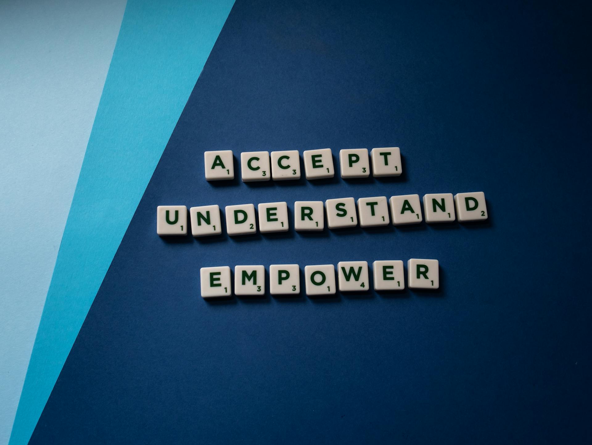 Understanding the Accessibility Act: A Shopify Merchant’s Guide to EAA 2025 9 Scrabble tiles on a blue background spelling Accept, Understand, Empower—core values supporting digital inclusion under the Accessibility Act EAA 2025.