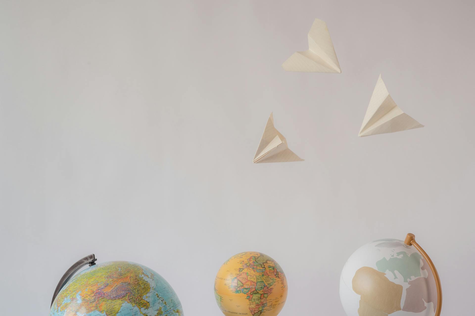 Paper airplanes flying above globes representing global email delivery and international ecommerce marketing reach.