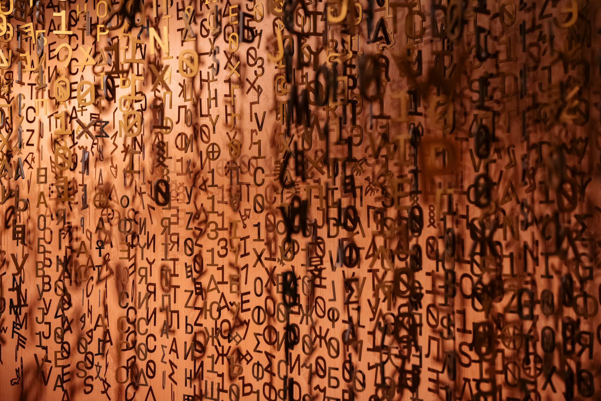 Hanging installation of multilingual letters and symbols, including Cyrillic and Greek characters, representing the diversity of character sets supported in modern web fonts and Unicode ranges.