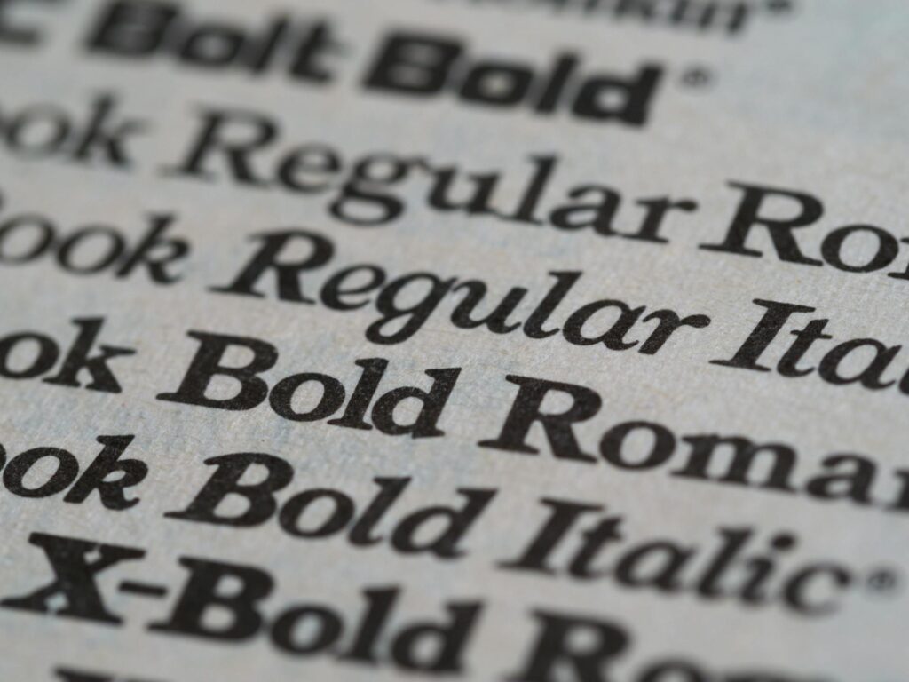 Close-up of printed text showcasing various web fonts, including different font weights and styles like Regular, Italic, and Bold, used in typography design.