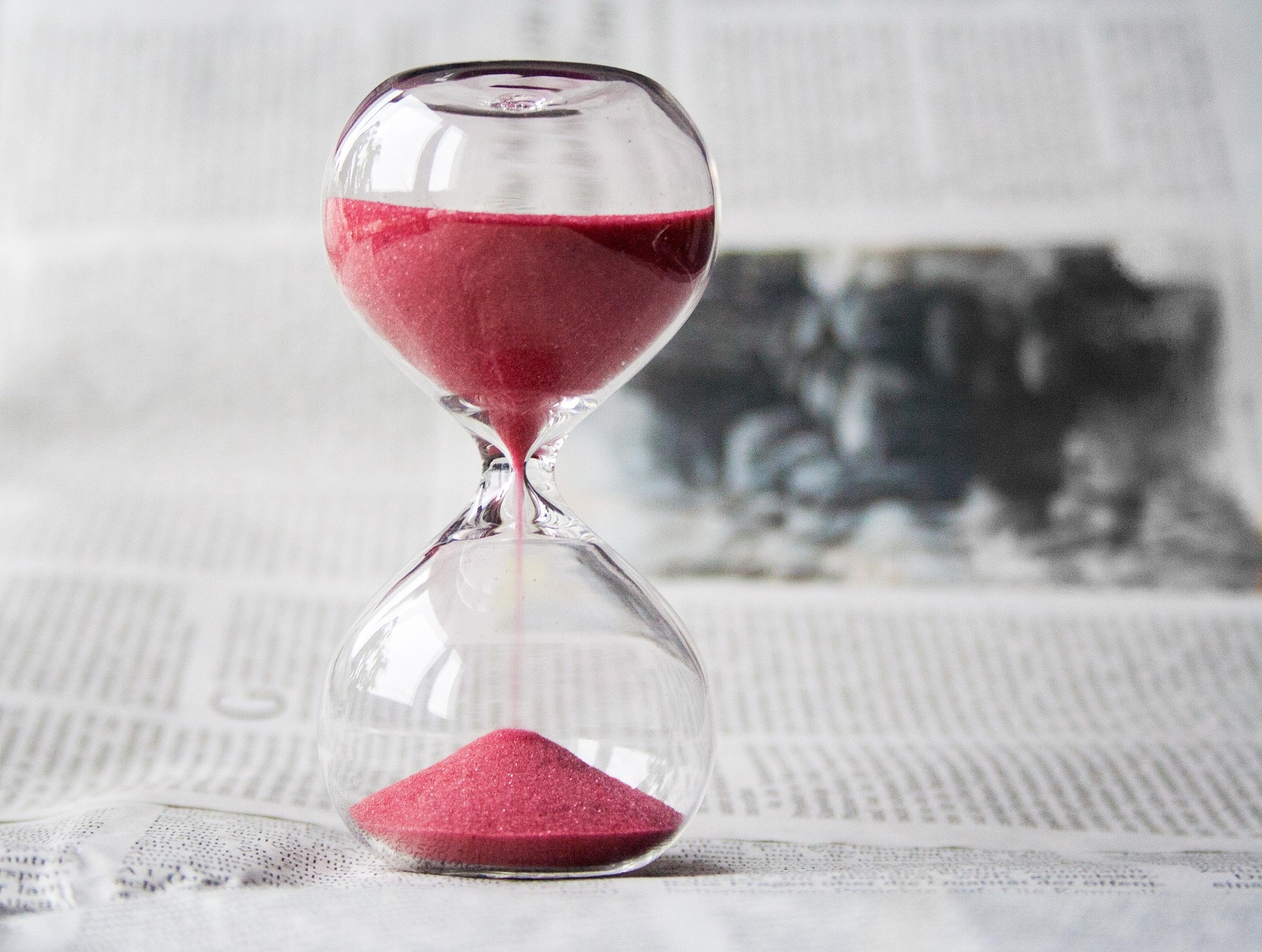 Hourglass with red sand symbolizing time spent on site and average session duration in web analytics