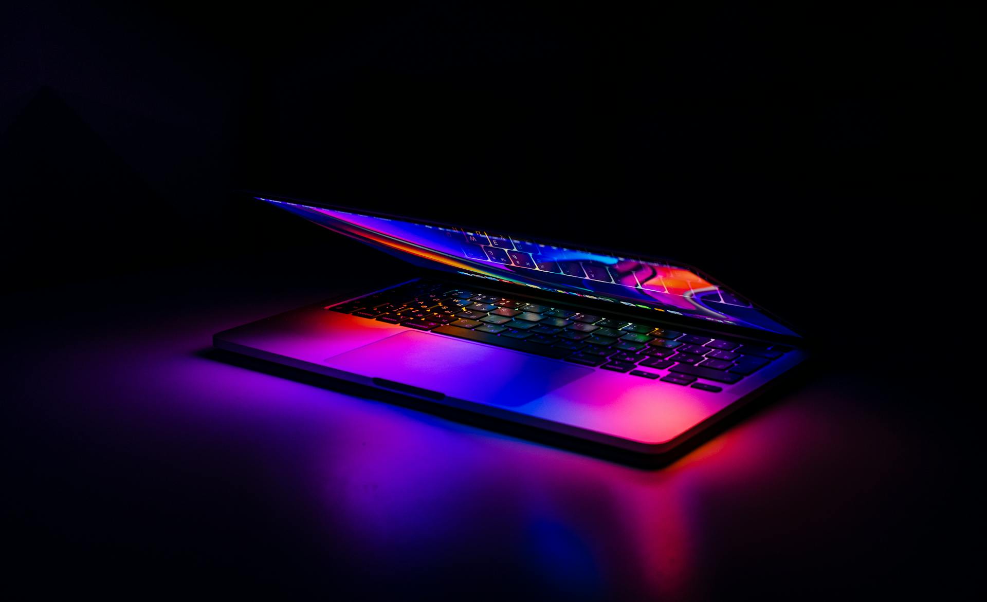 High-performance laptop glowing with neon lights in dark setting, symbolizing ecommerce conversion optimization, site speed, and digital performance.