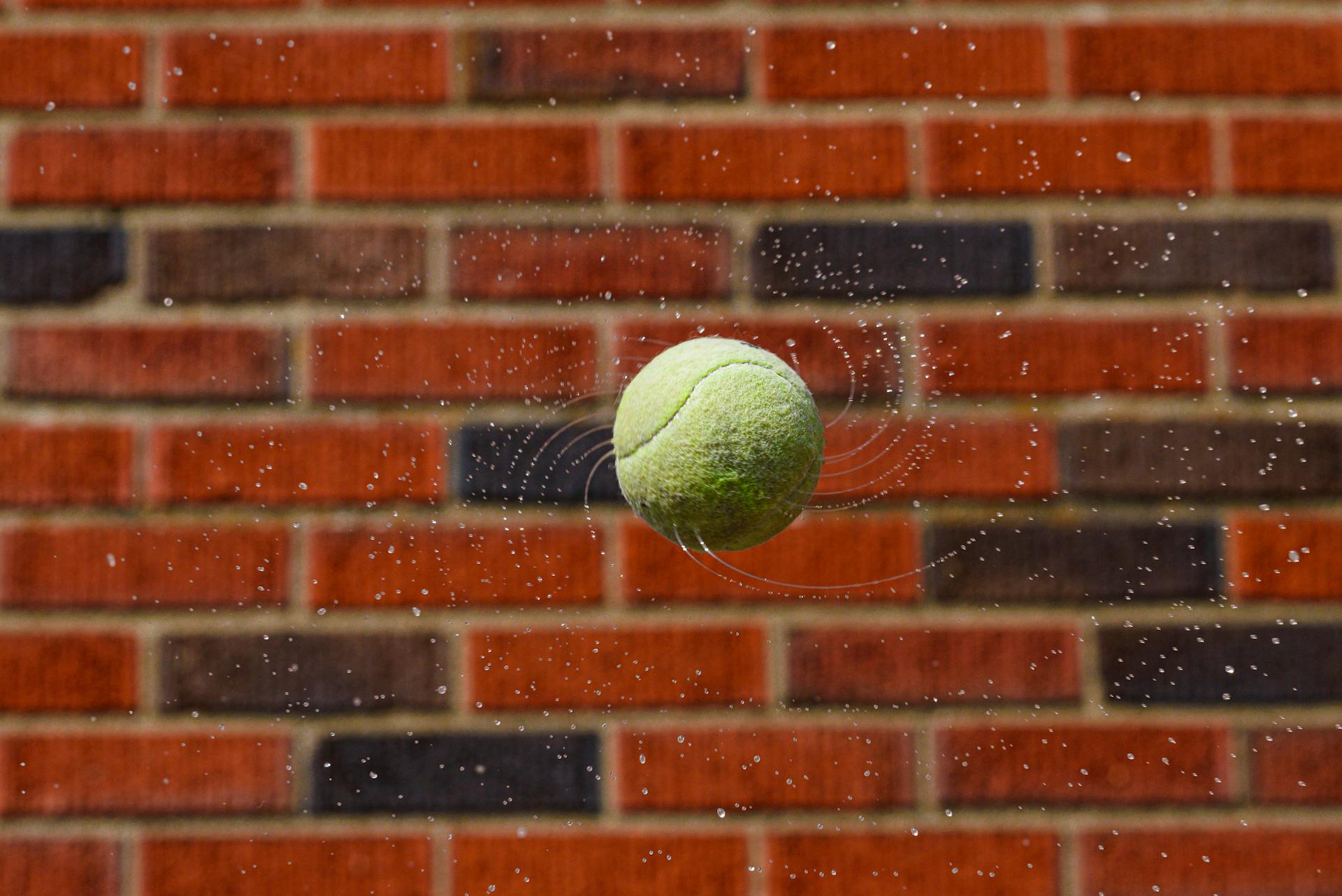 Close-up of tennis ball rebounding against wall representing average bounce rate for ecommerce