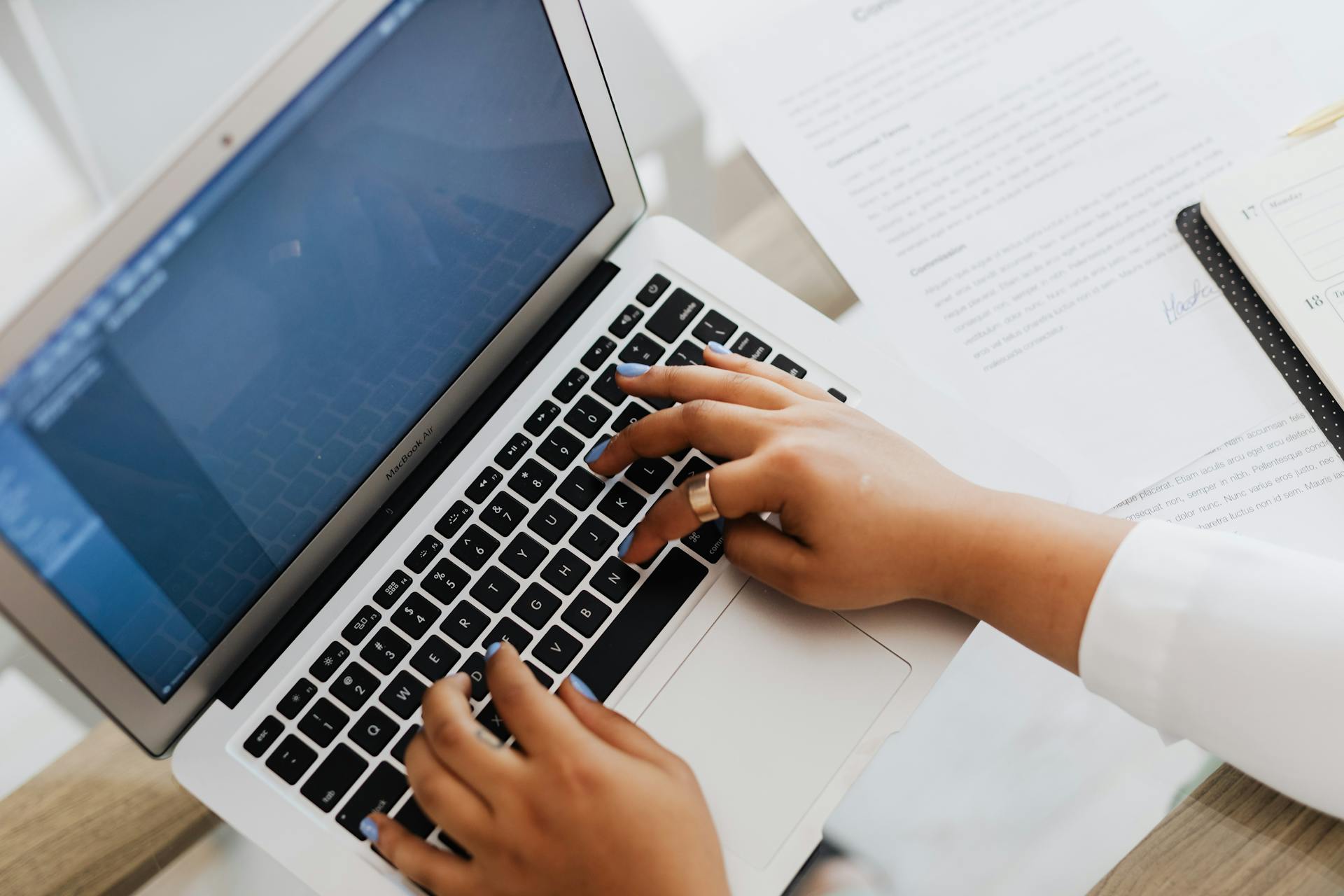 Person working on a laptop, representing Shopify store management, theme customization, and the growing number of apps, scripts, and render-blocking resources that can impact page speed and storefront performance.
