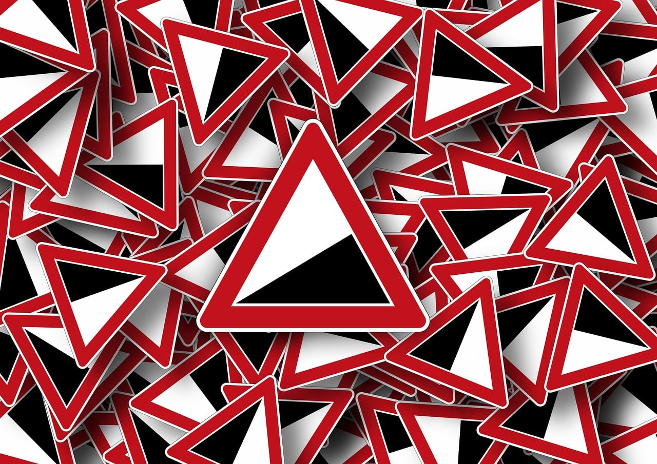 Warning icons symbolizing the risks of a slow Shopify store and revenue loss 